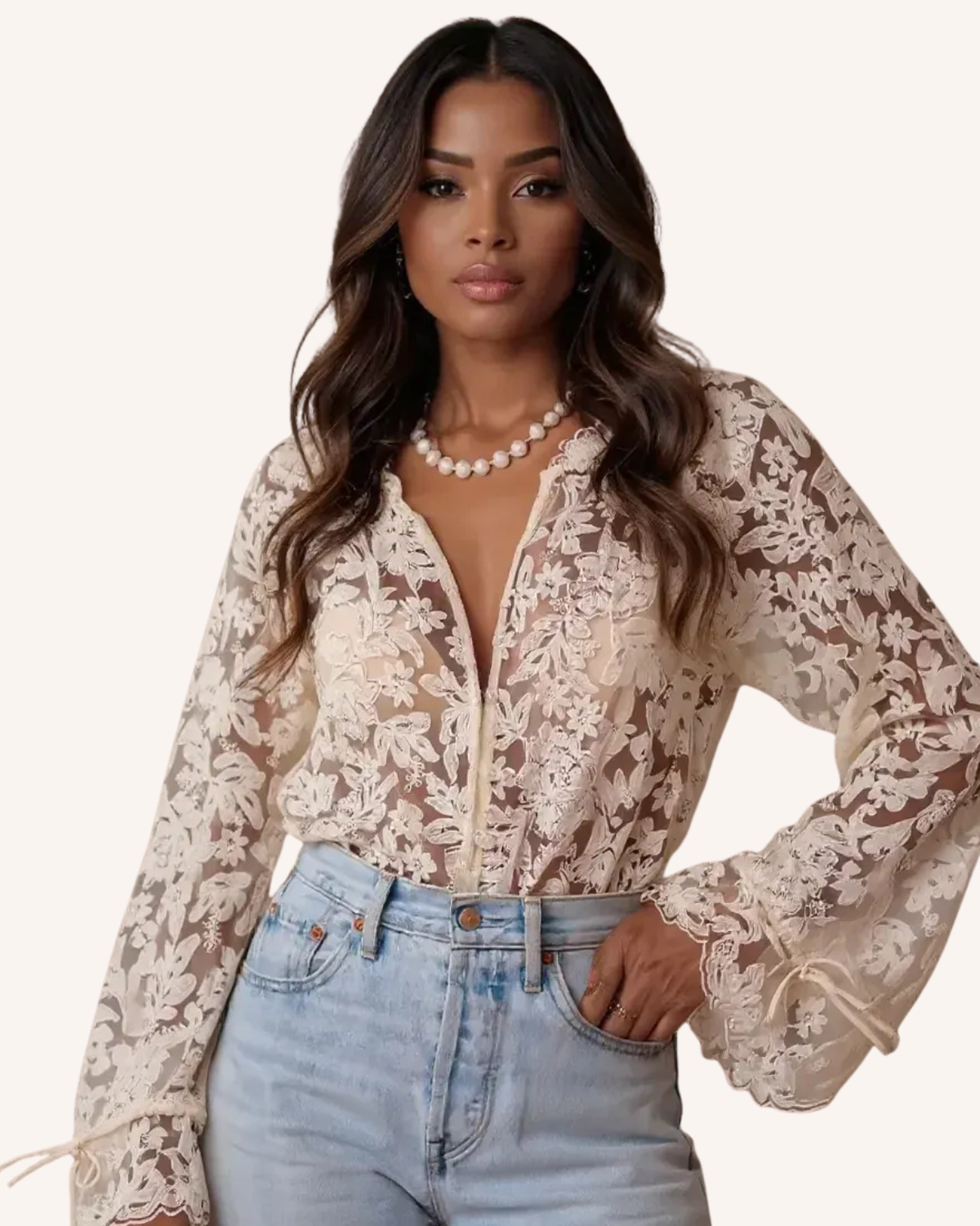 Woman in sheer floral lace blouse and light blue jeans, wearing a pearl necklace