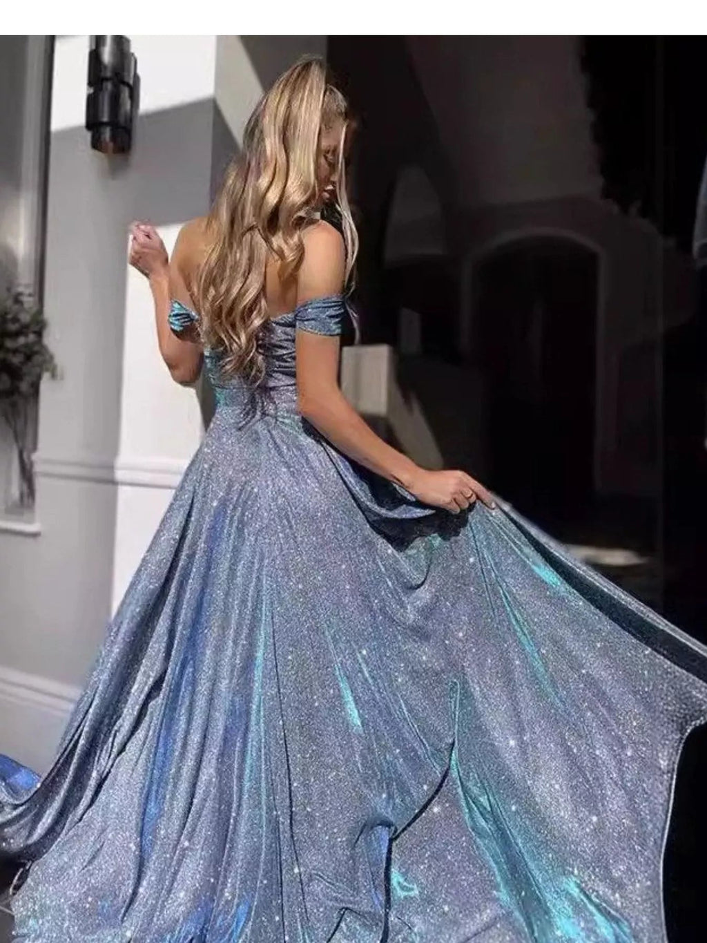 Detailed view of the flowing maxi skirt and dramatic high side slit on the sparkly evening gown